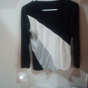 Black white and gray top, Does not say brand Or size. I would guess a medium.